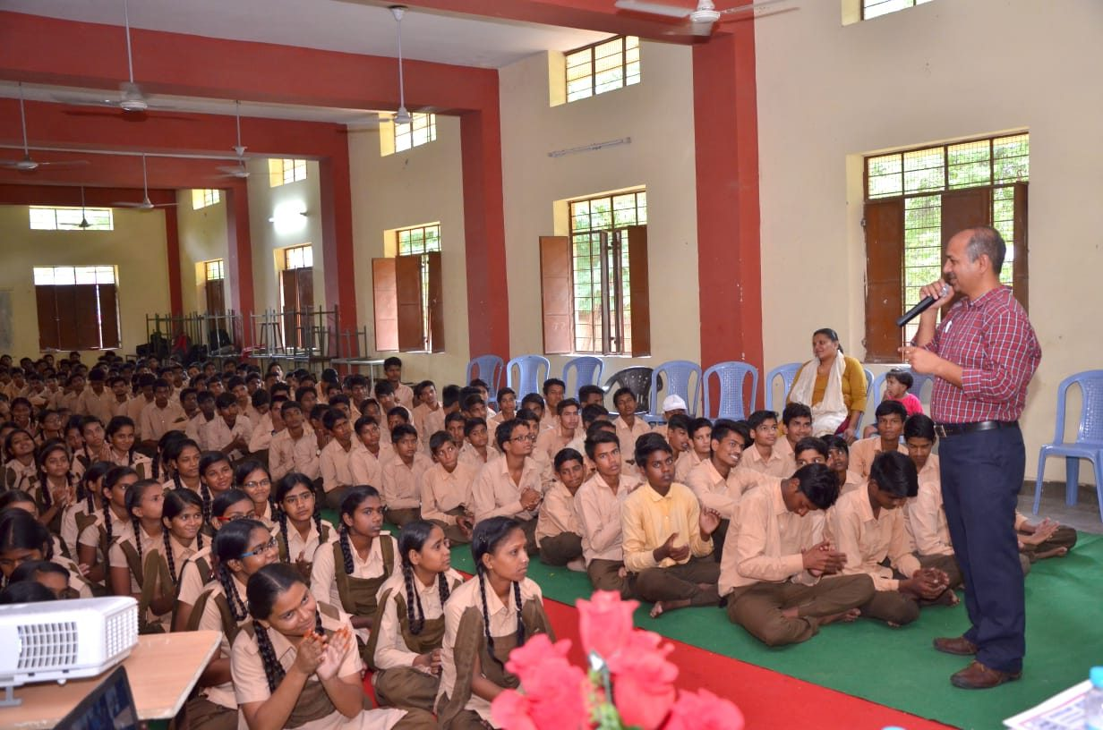 A facilitator addressing students during a career guidance session in a school