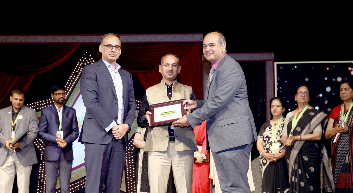PURE India Trust leadership receiving a national recognition award on stage